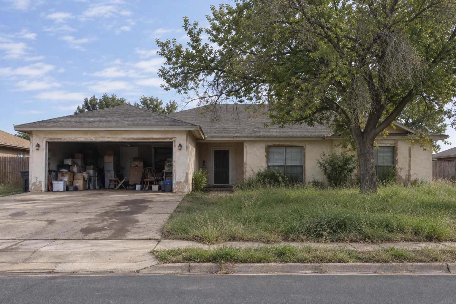 Before: A home with an overgrown front lawn, weathered exterior, and a garage full of boxes and furniture